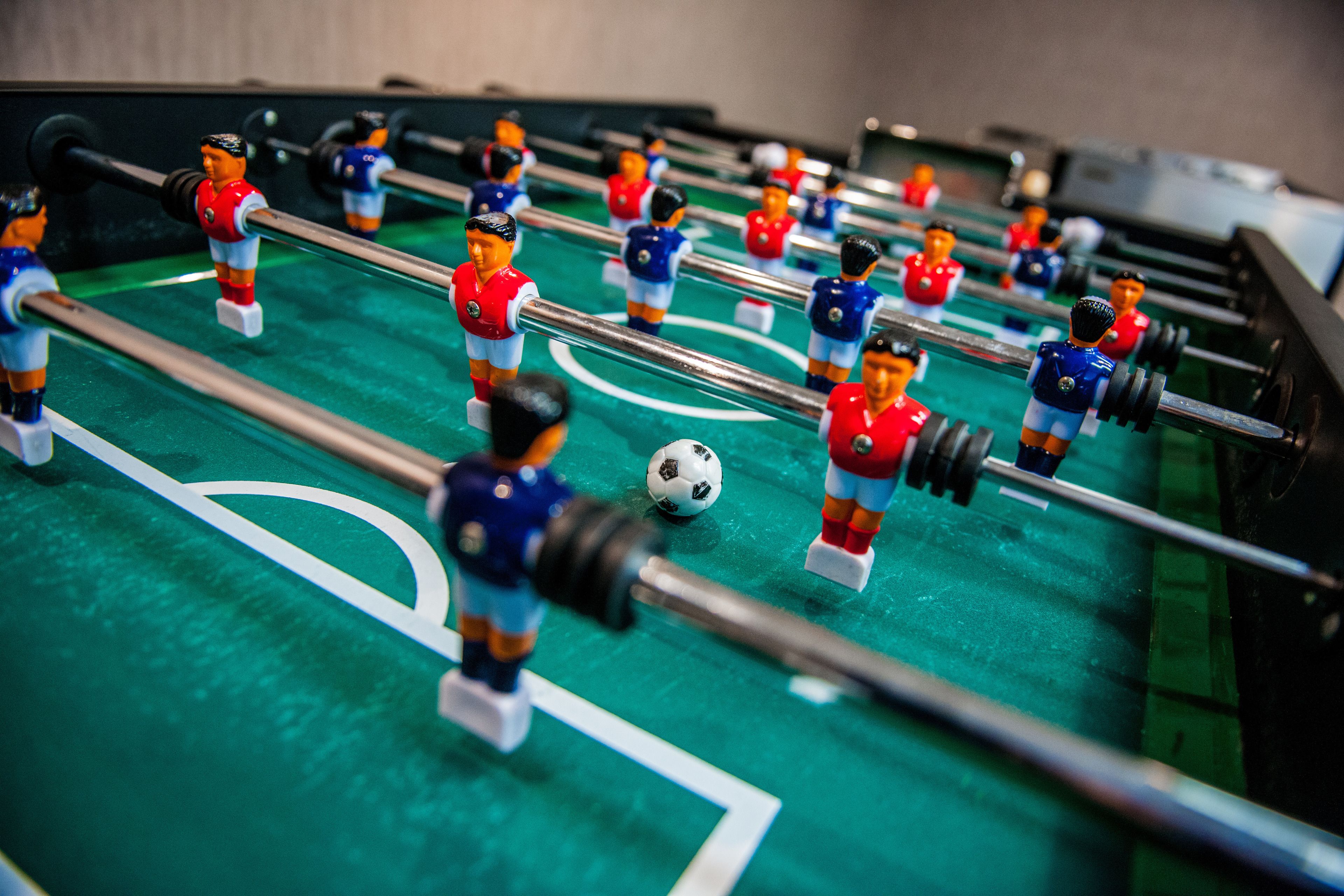 A foosball table with players in red and blue uniforms.