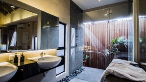 Un baño moderno con dos lavamanos, un espejo grande y una zona de ducha.