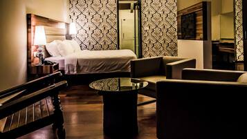 Una habitación de hotel con una cama, un sofá, una mesita de café y un banco.