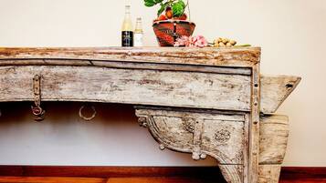 A rustic wooden table with a decorative basket, two bottles, and a potted plant.