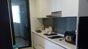A modern kitchen with white cabinets, a black countertop, and a built-in oven.