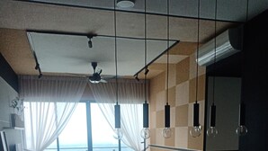 A modern living room with a dining area, large windows, and a view of the sea.