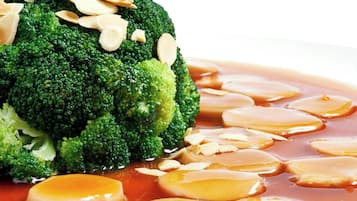 A dish with broccoli and sliced almonds on a white plate.