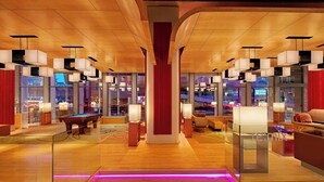 Eine großzügige Lobby mit Billardtisch, bequemen Sitzgelegenheiten und moderner Beleuchtung.