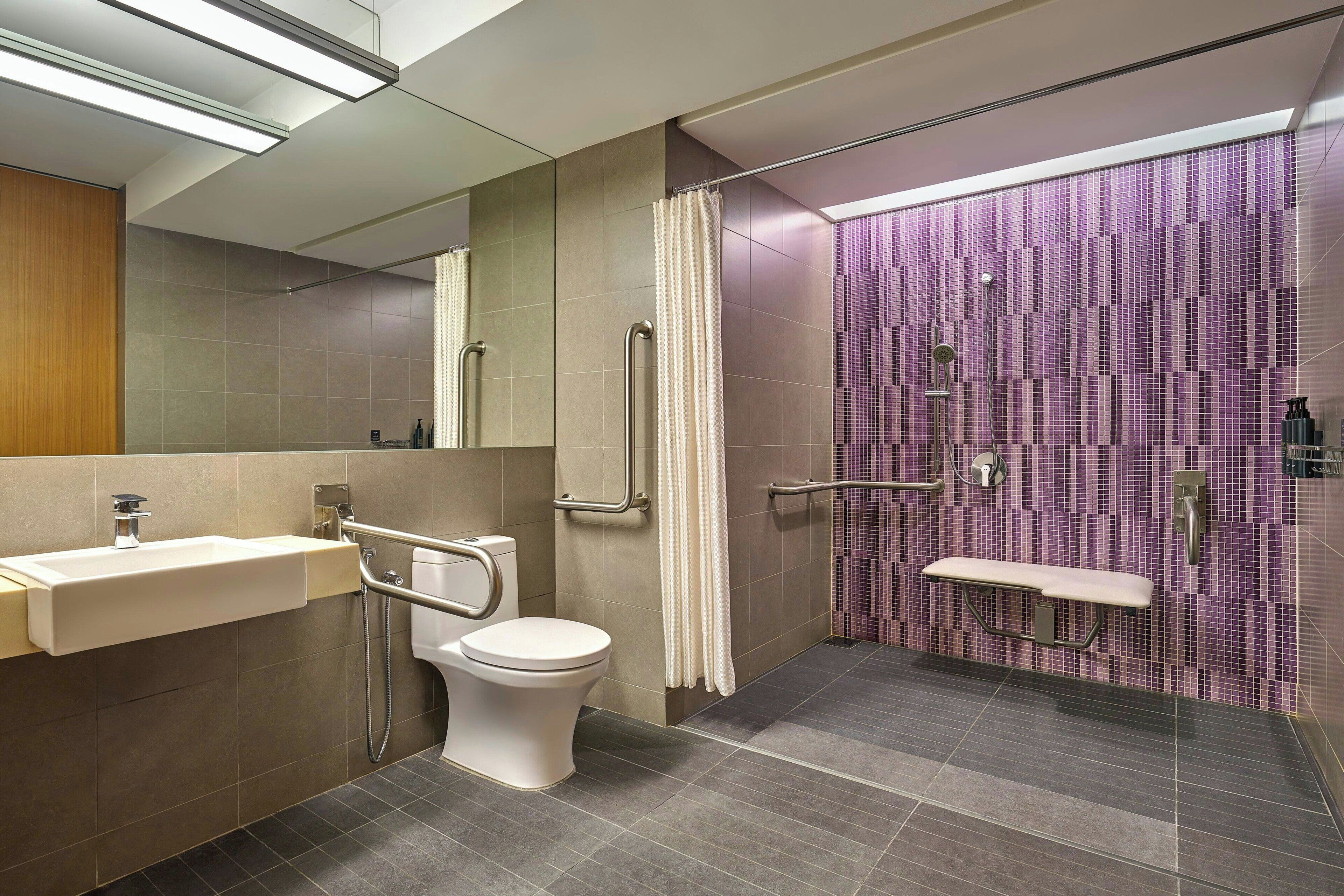 Un baño moderno con inodoro, lavamanos y zona de ducha.
