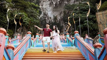 A couple on a colorful staircase with a monkey on the railing.