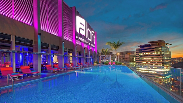 Ein Hotel mit Pool, roten Liegestühlen und einem Schild mit der Aufschrift 'All In'.