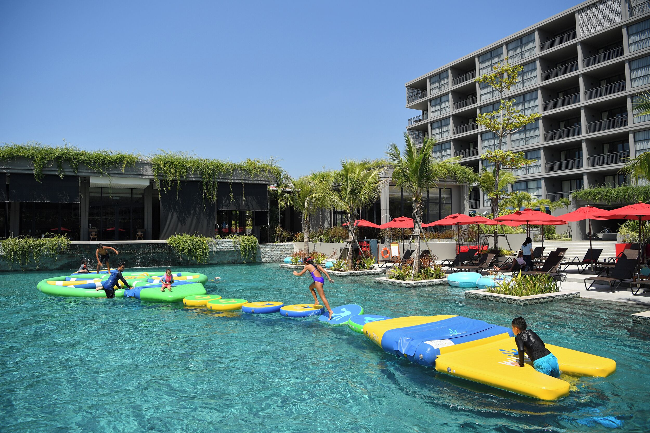 Ein Poolbereich mit Wasserrutschen und Liegestühlen.