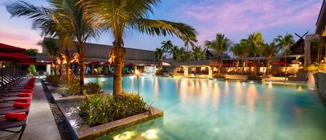 Alberca al aire libre, sombrillas en la alberca y camastros