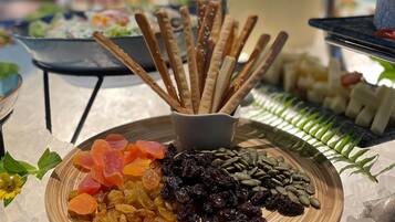 A buffet table with various food items including dried fruits, nuts, and crackers.