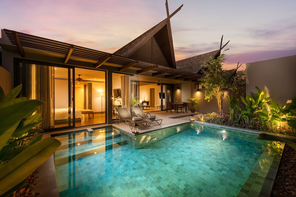 Une maison moderne dotée d’une piscine, de grandes fenêtres et d’un intérieur bien éclairé.