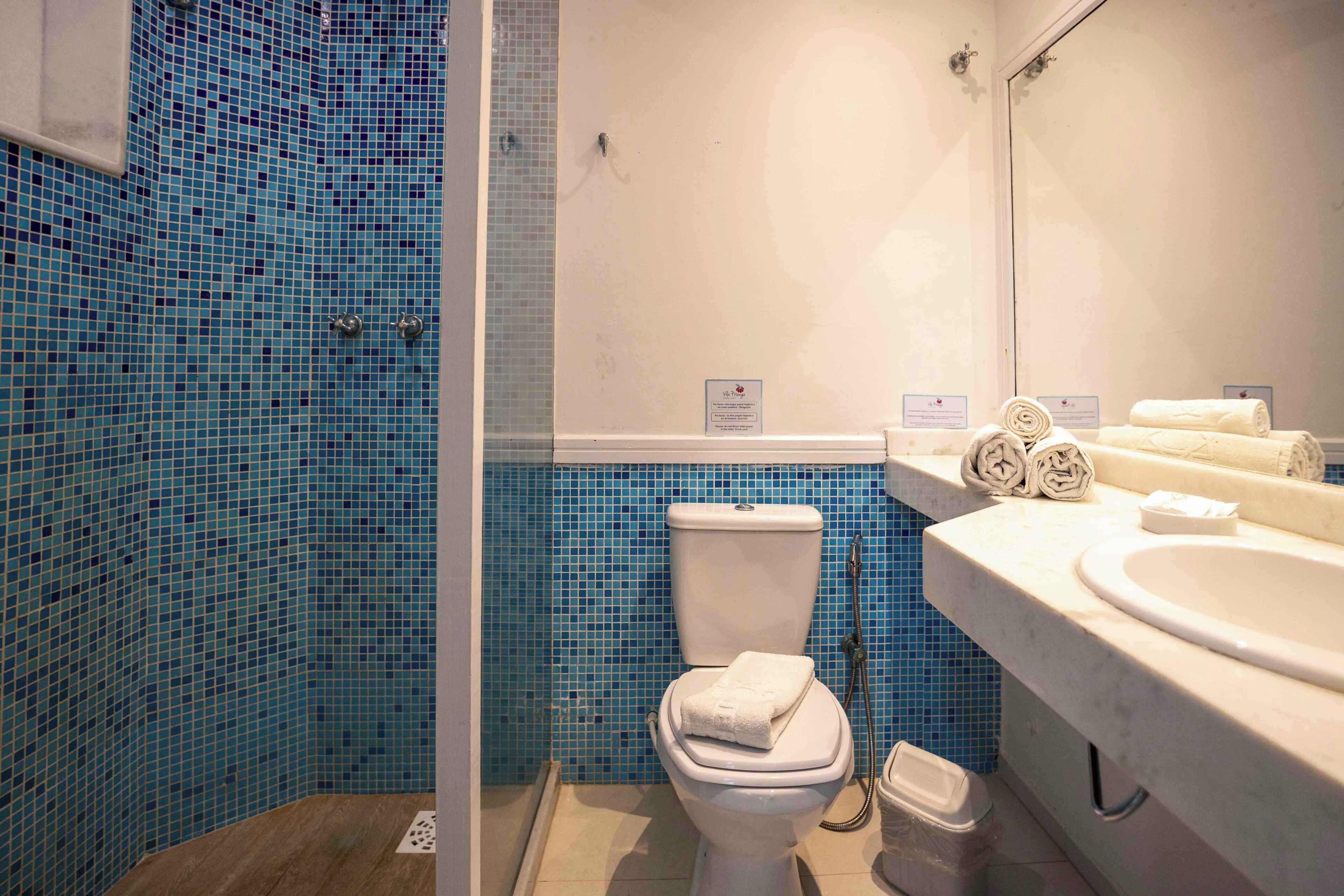 Un baño con inodoro, lavamanos y cabina de ducha.