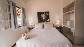 Un dormitorio con una cama grande, dos mesitas de noche con lámparas, un cuadro en la pared y un armario.