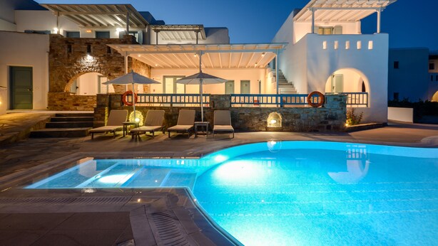 A modern hotel with a swimming pool, outdoor seating, and a stone archway. - Hotel Francesca (Naxos)