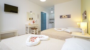 A hotel room with two beds, a desk, a TV, and a bathroom. - Hotel Francesca (Naxos)
