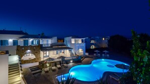 A modern hotel with a swimming pool, outdoor seating, and a staircase leading to the upper floors. - Hotel Francesca (Naxos)