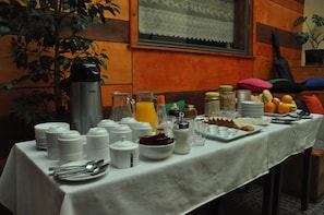 Una mesa con un bufé de desayuno y diversas opciones de alimentos y condimentos.