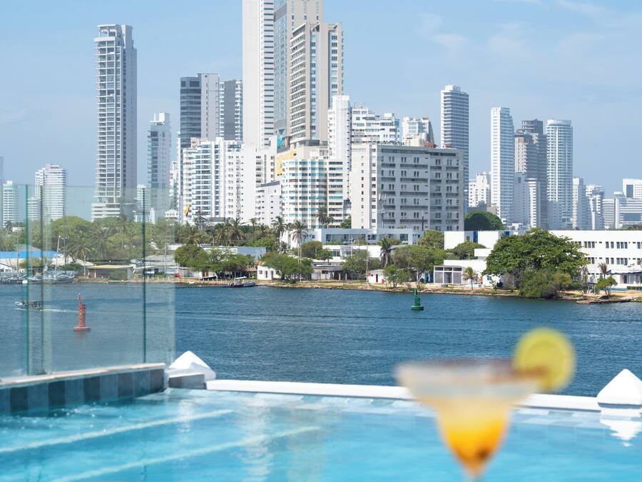 Una piscina al aire libre, sombrillas, sillones reclinables de piscina