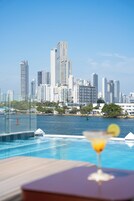 Una piscina al aire libre, sombrillas, tumbonas