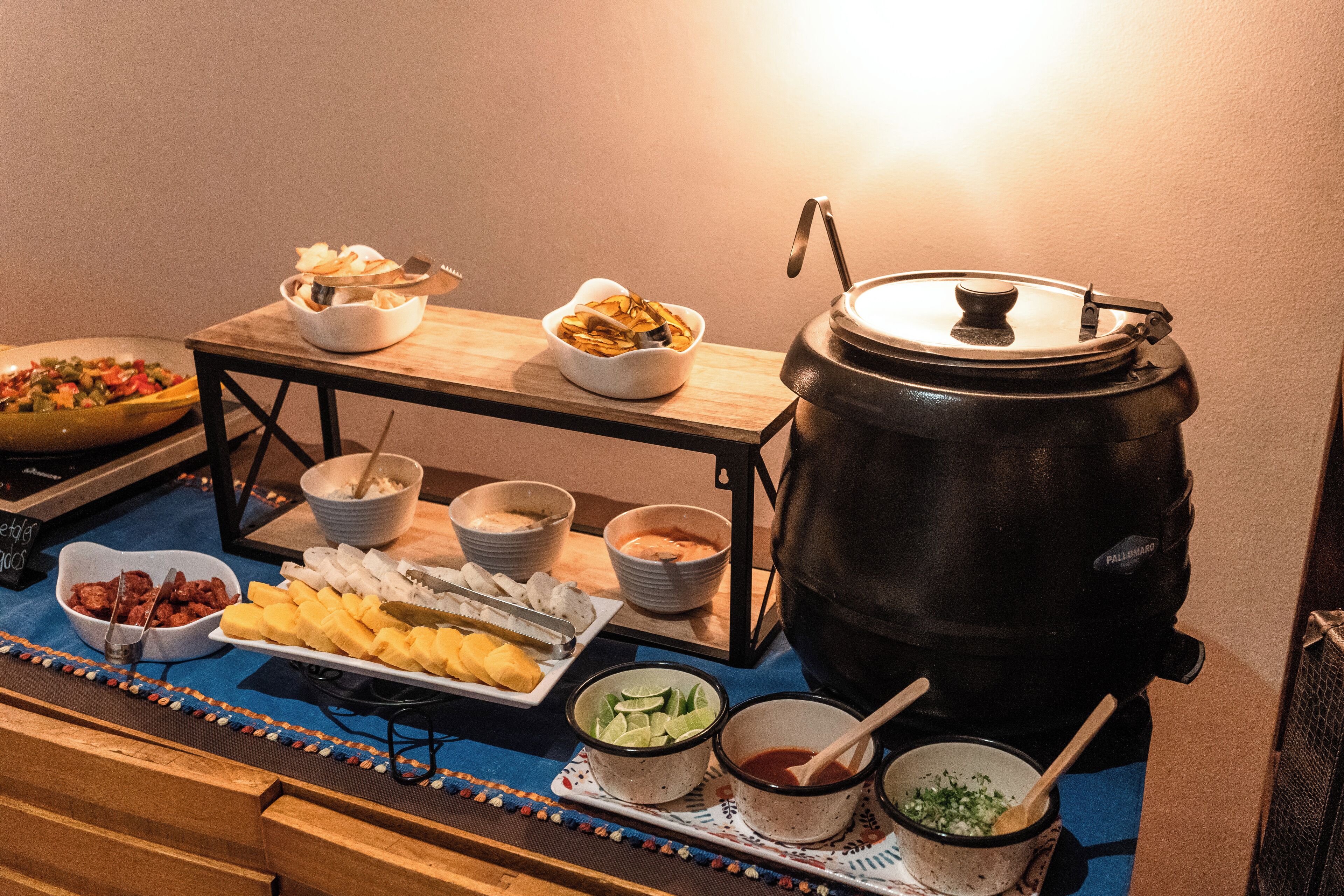 Una mesa de buffet con diferentes opciones de comida y una cafetera grande.