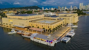 Un grand bâtiment historique doté d’une cour intérieure, entouré d’eau et de bateaux.