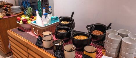 A buffet setup with various food items and serving utensils.