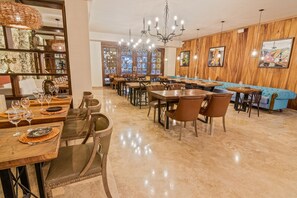 Un restaurante con paredes de madera, candelabros y un área de asientos con cojines azules.