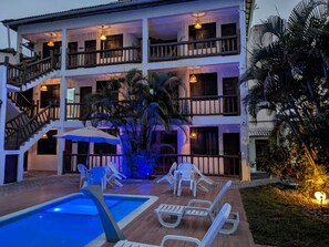 Ein mehrstöckiges Hotel mit Pool, Außenbereich und einer Treppe.