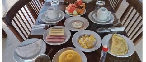 A breakfast table with various dishes including eggs, bread, and a jug of milk.