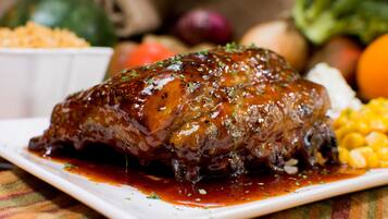 Un plato de carne glaseada con verduras.
