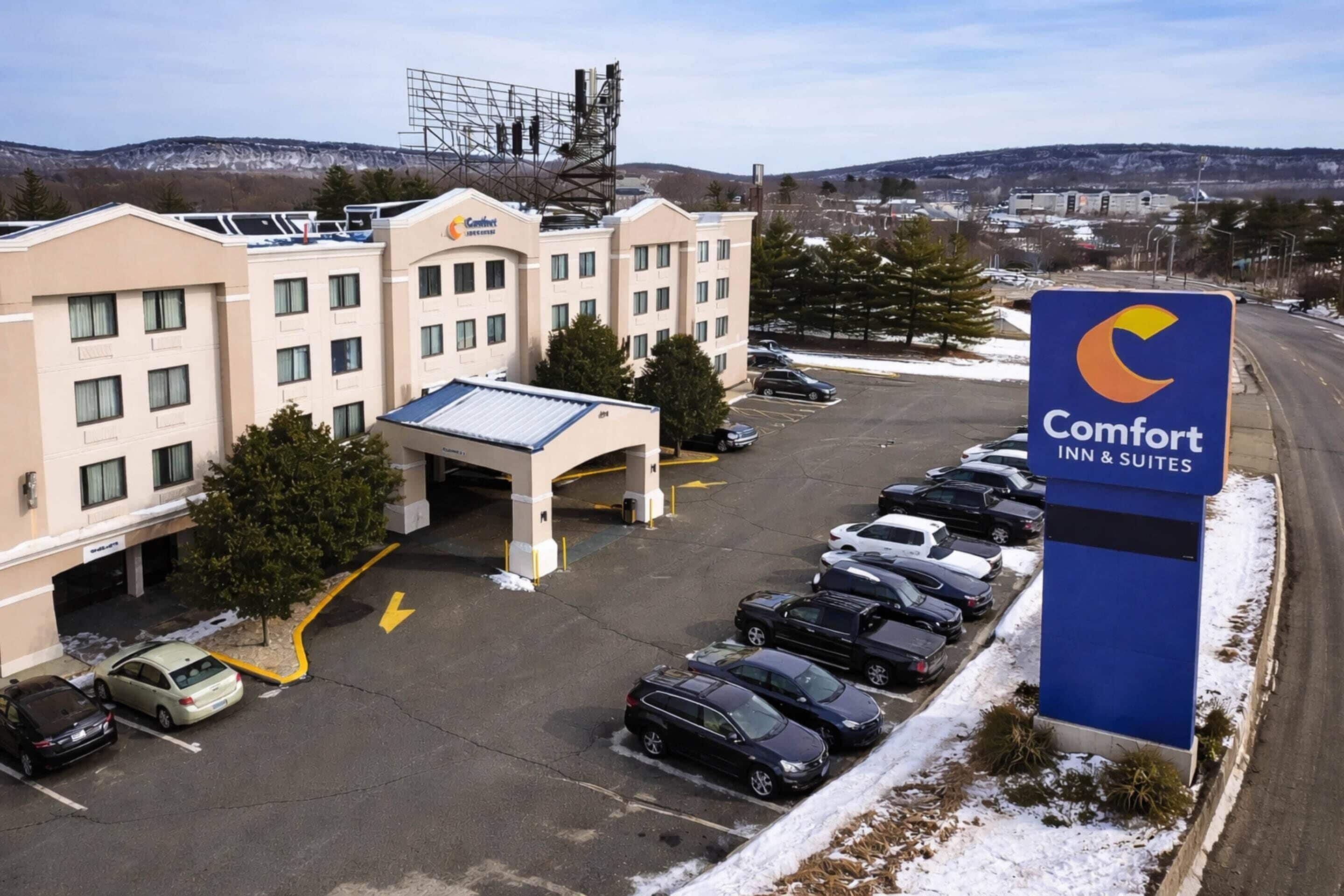 A Comfort Inn & Suites hotel with a parking lot, a covered entrance, and a signboard.