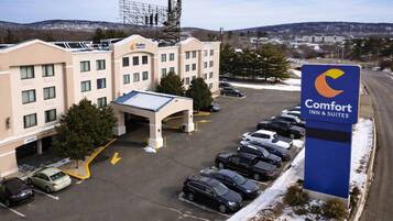 A Comfort Inn & Suites hotel with a parking lot, a covered entrance, and a signboard.