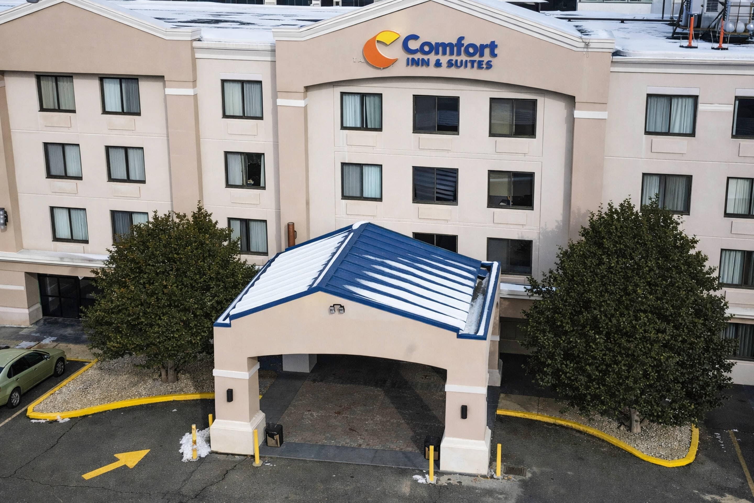 A Comfort Inn & Suites hotel with a central entrance, multiple floors, and a parking area.