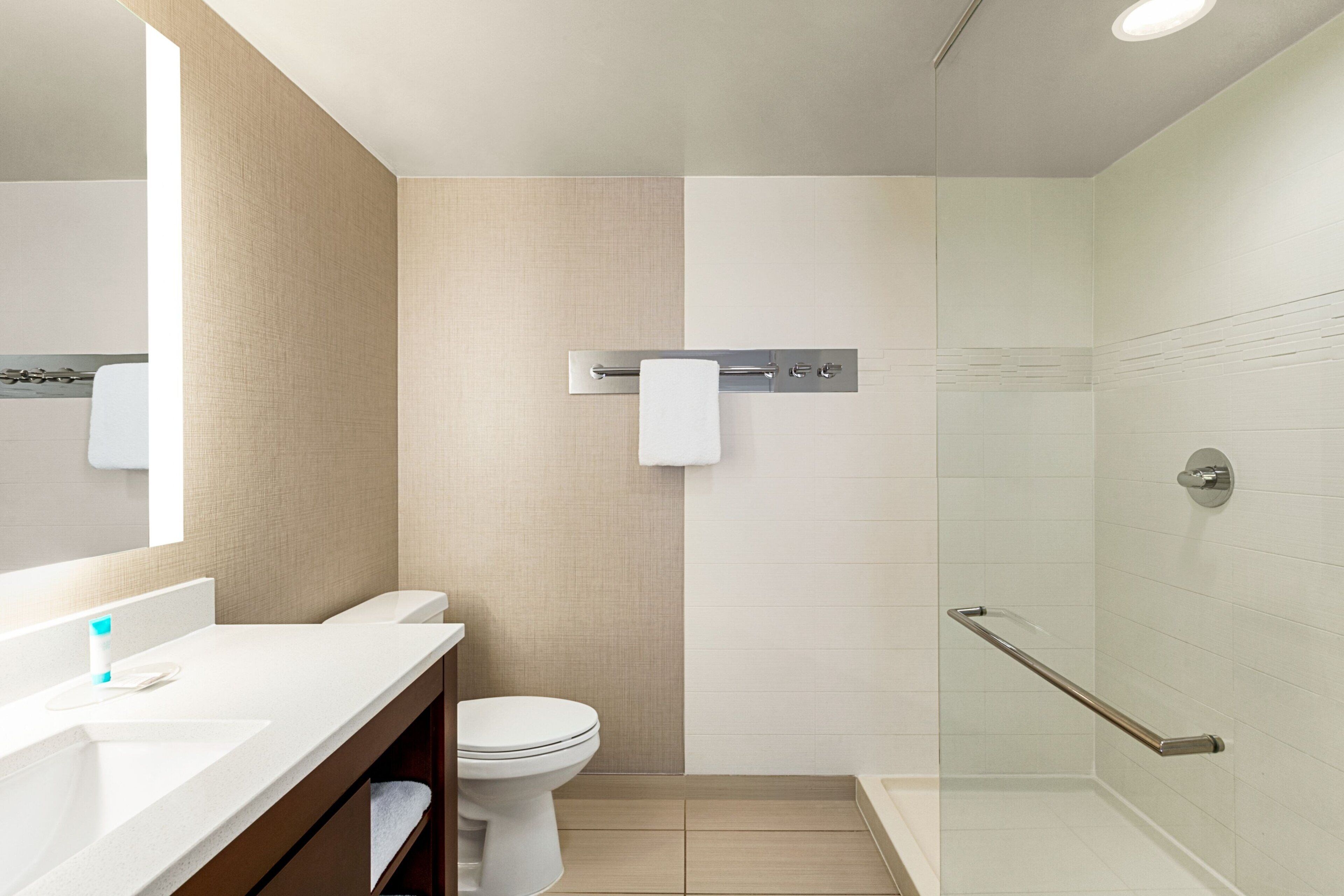 A modern bathroom with a toilet, sink, and shower area.