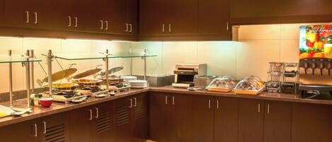 A modern kitchen with dark wood cabinets, a glass display case, and a coffee machine.