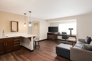 A modern hotel room with a kitchenette, a dining area, a living space with a sofa and a TV, and a large window providing natural light. - Residence Inn Denver Cherry Creek (Denver)