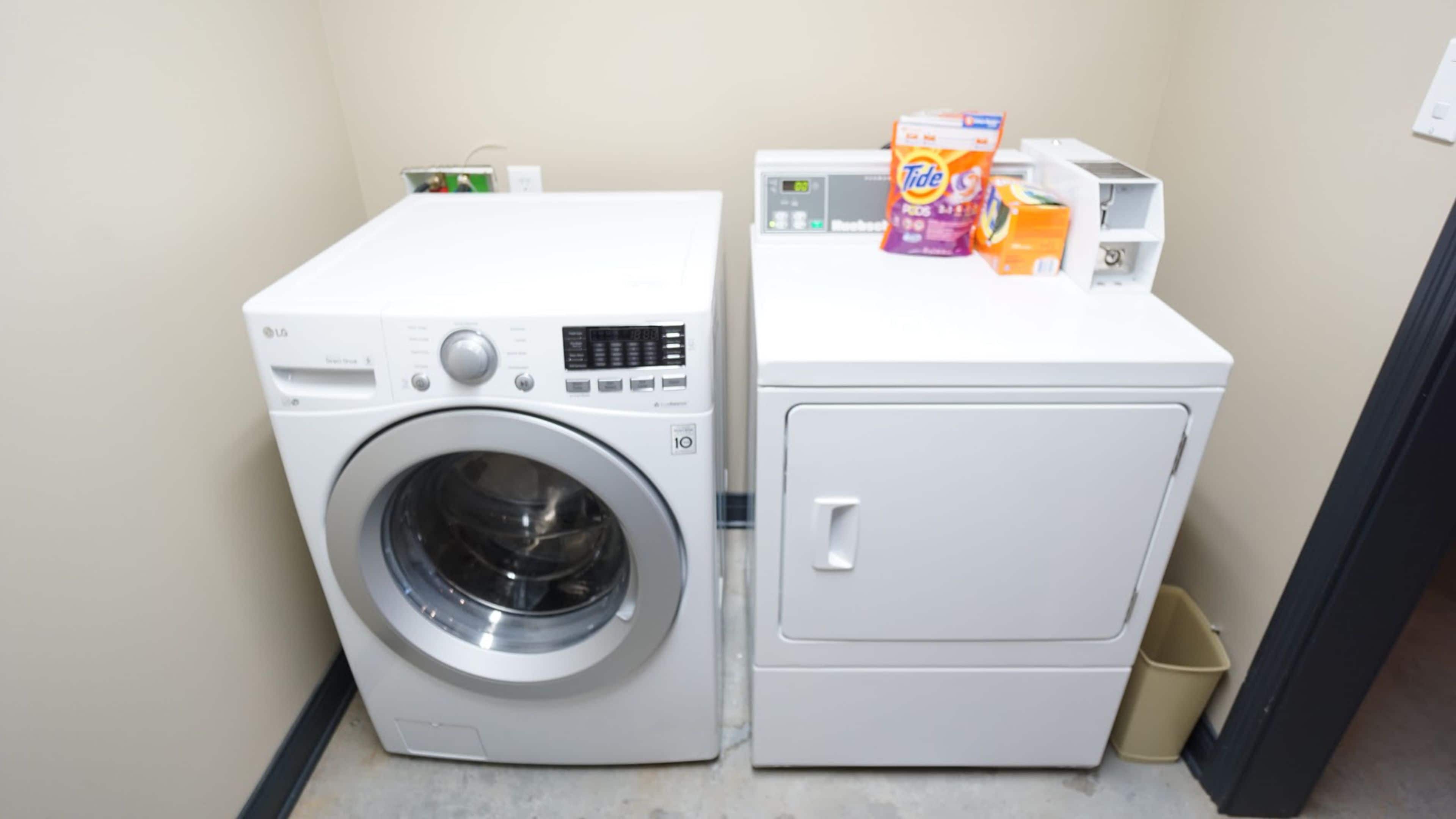 A compact laundry area with a front-loading washing machine and a built-in dryer.