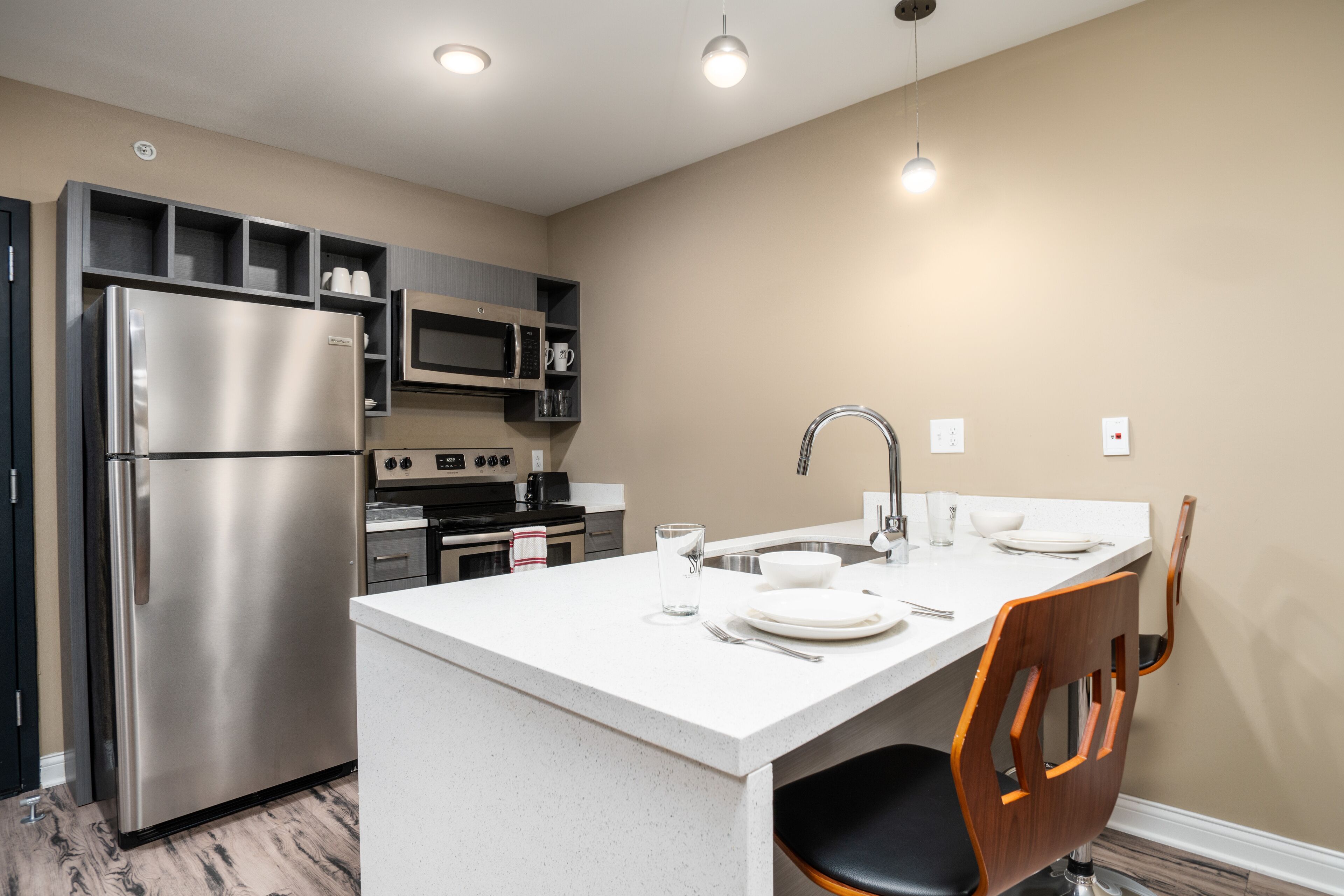 A modern kitchen with a stainless steel refrigerator, a microwave, and a sink.