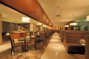 A modern restaurant with a long counter, multiple dining tables, and booths.