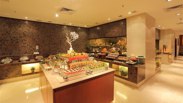 A buffet area with various food items and a decorative tree sculpture. -  Mysore County Retreat (Mysore)