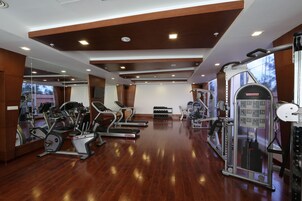 A gym with treadmills, elliptical machines, and weight machines.
