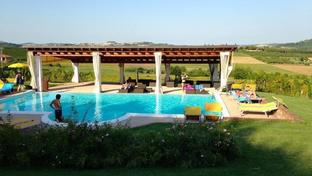 Une piscine dotée d’une pergola et de chaises longues.