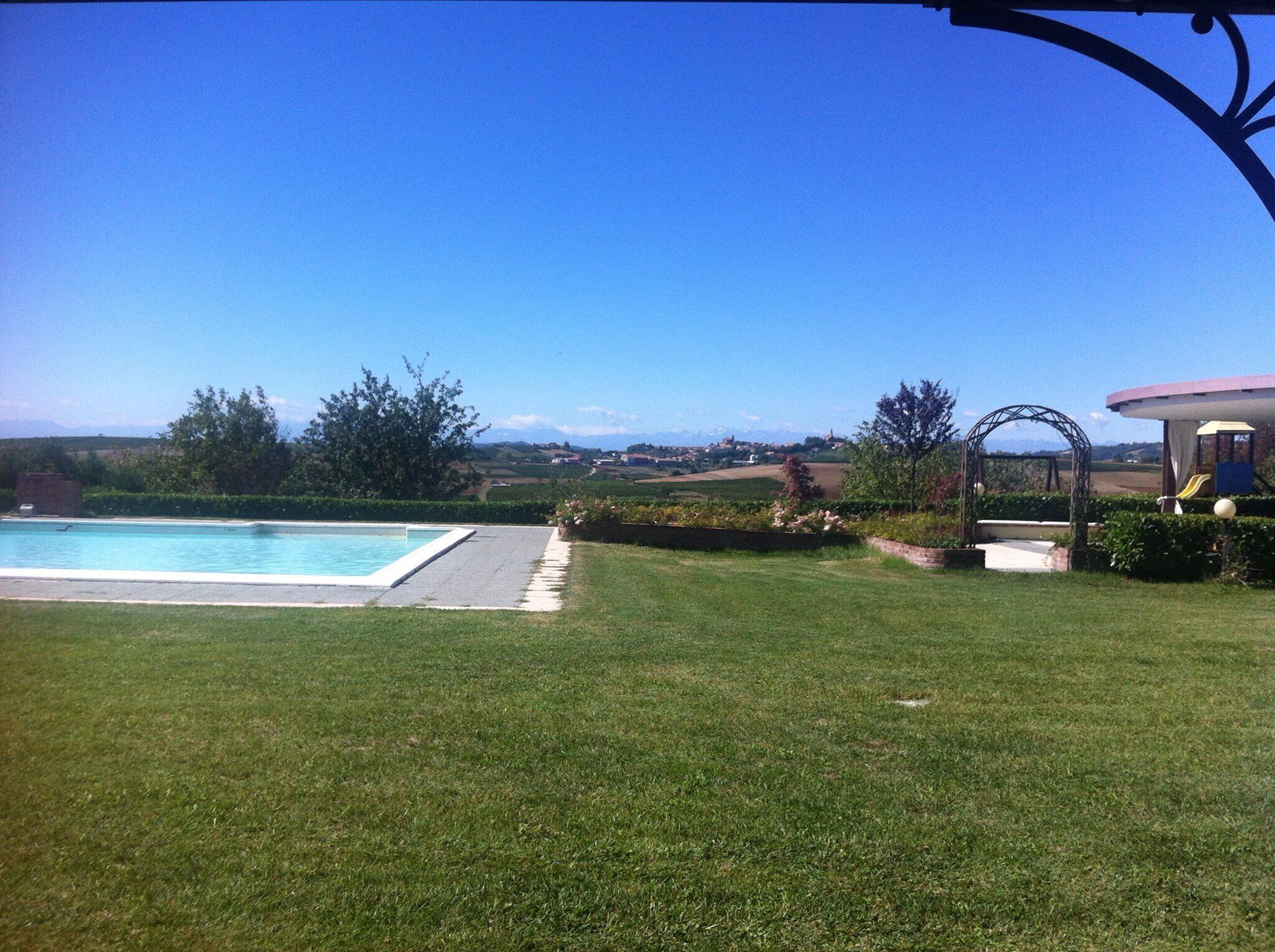 A swimming pool with a clear view of the countryside and mountains in the distance.