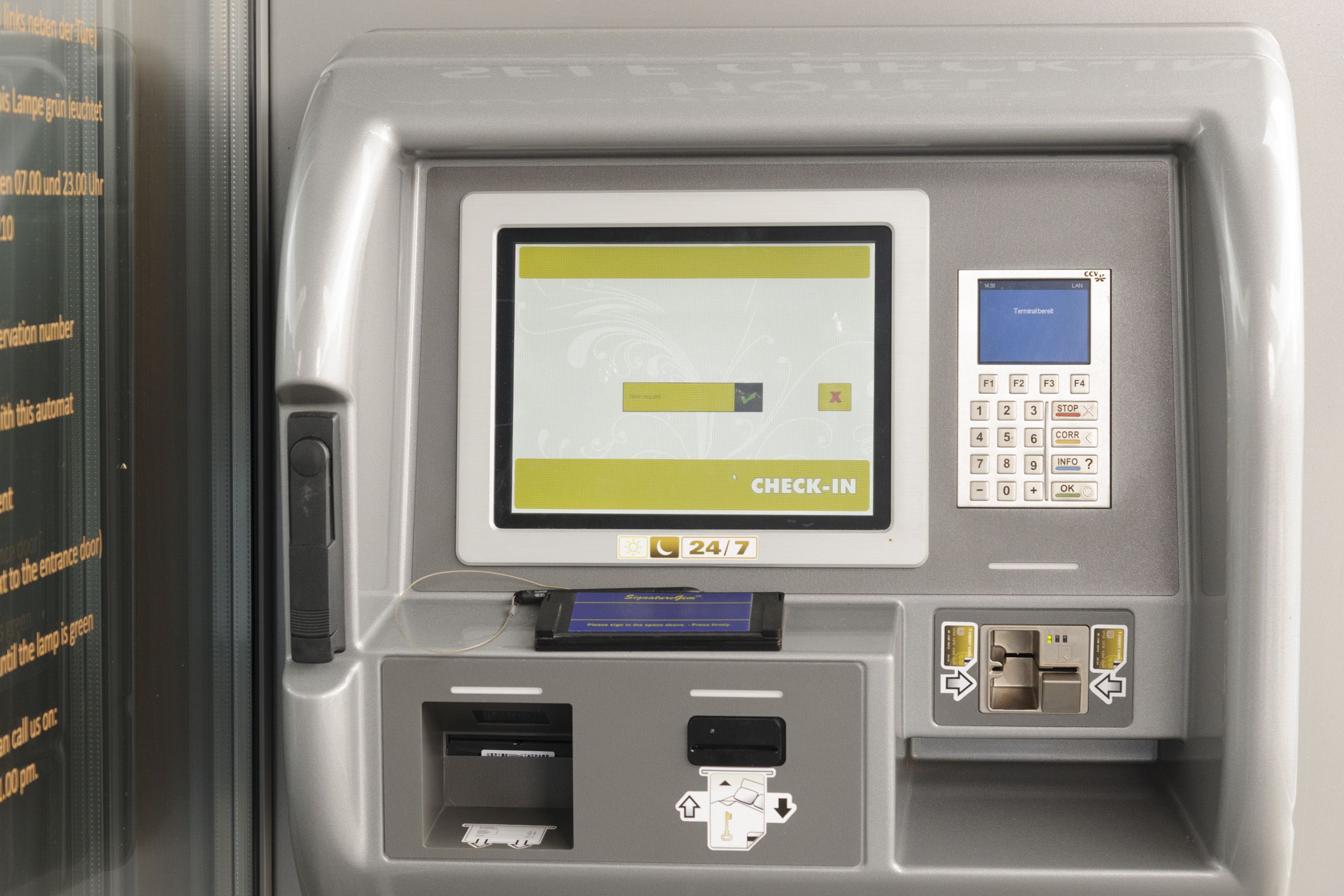A self-service check-in kiosk with a screen, keypad, and card reader.