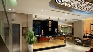 A modern hotel lobby with a reception desk, seating area, and a decorative ceiling. - Sorriso Hotel (Istanbul)