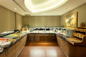 Un buffet proposant une variété de plats, des meubles en bois et un plafond doté d’un éclairage encastré.