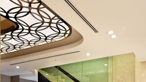 A modern lobby with a glass staircase, a reception desk, and seating area. - Sorriso Hotel (Istanbul)