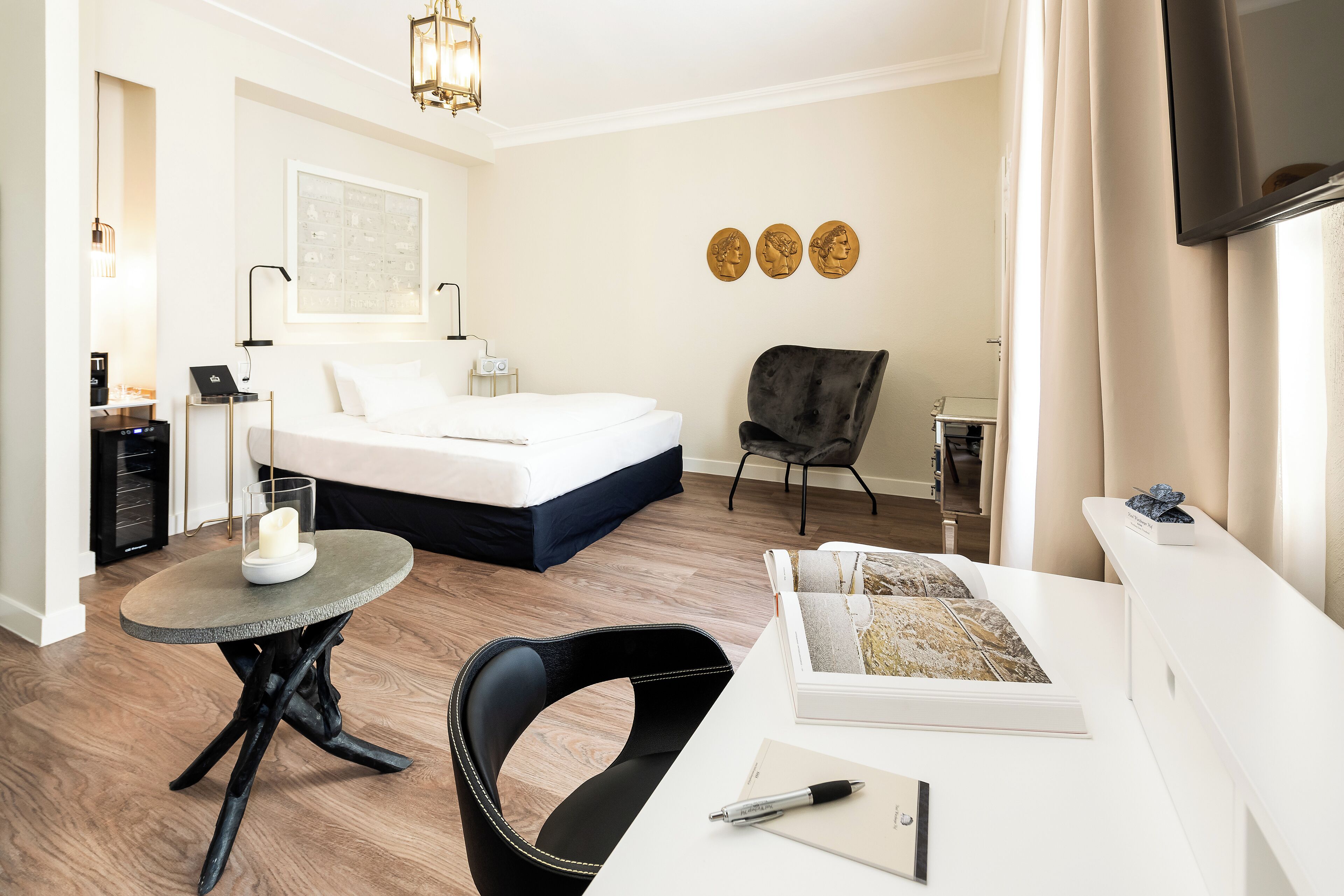 Un dormitorio moderno con una cama, un escritorio, una silla y una mesita.