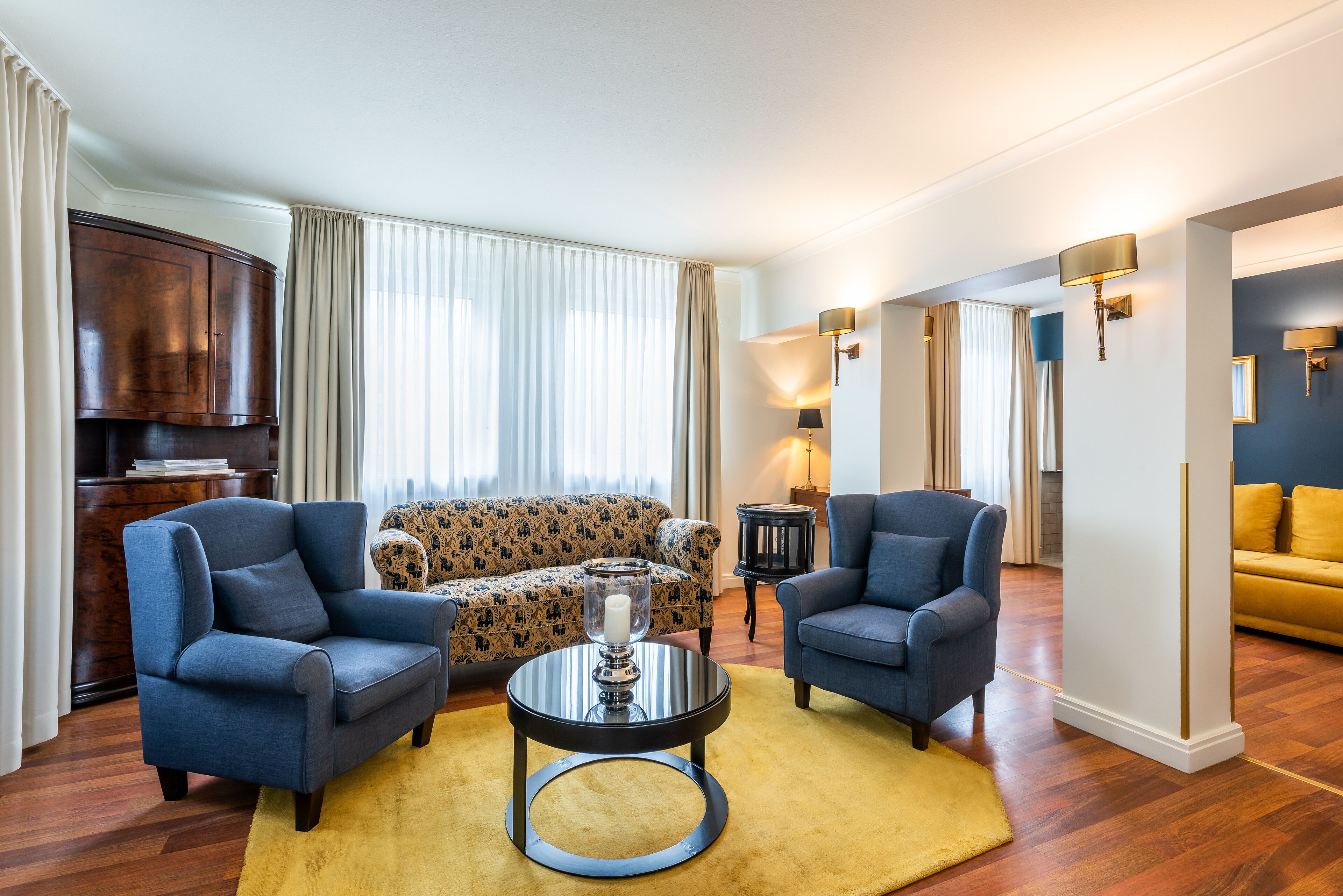 A living room with a sofa, two armchairs, a coffee table, and a TV.