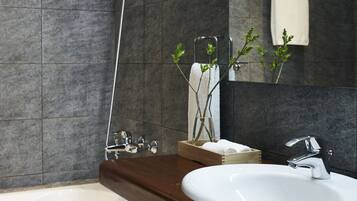 Un baño moderno con bañera, lavamanos blanco y ducha.